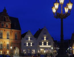 Historische Gebäude und Laterne bei Nacht in einer Stadt.