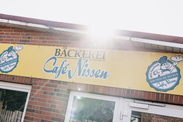 Fassadenschild der Bäckerei Café Nissen an einer roten Backsteinwand 