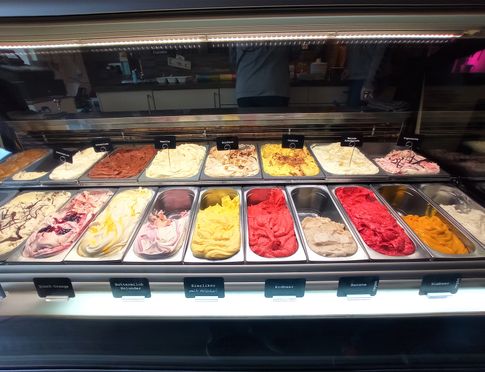 Diverse bunte Eissorten der Eisdiele sind aufgereiht für den Kunden zur Auswahl