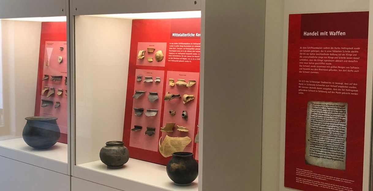Ausstellungsstücke in Vitrinen mit rotem Hintergrund 