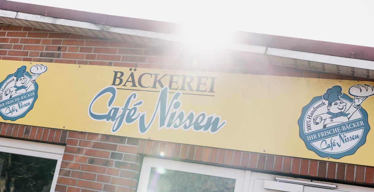 Fassadenschild der Bäckerei Café Nissen an einer roten Backsteinwand 