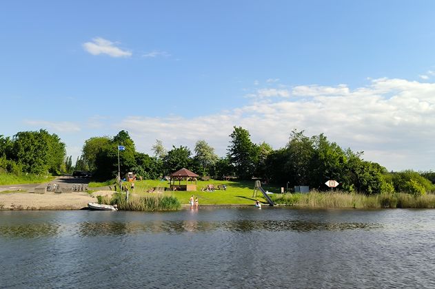 Eine Badestelle am Fluss mit Pavillon und Liegewiese