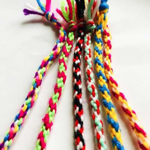 Mehrfarbige, geflochtene Kordeln aus Wolle auf weißem Hintergrund.