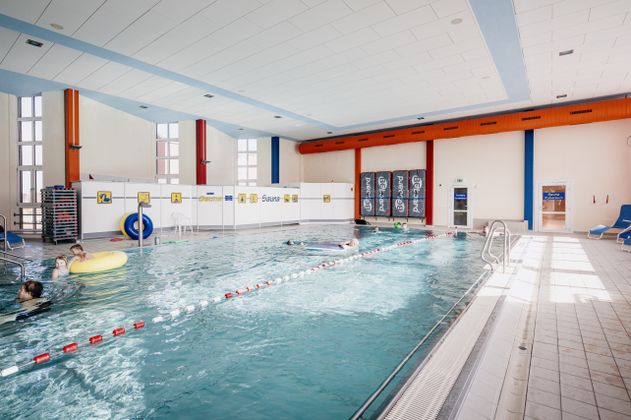 Ein Schwimmbecken mit spielenden Menschen in Reifen