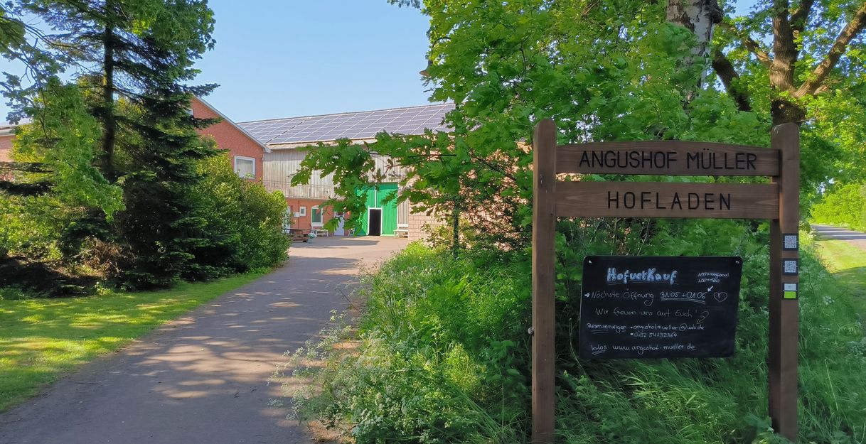Willkommensschild und Hofauffahrt des Betriebes