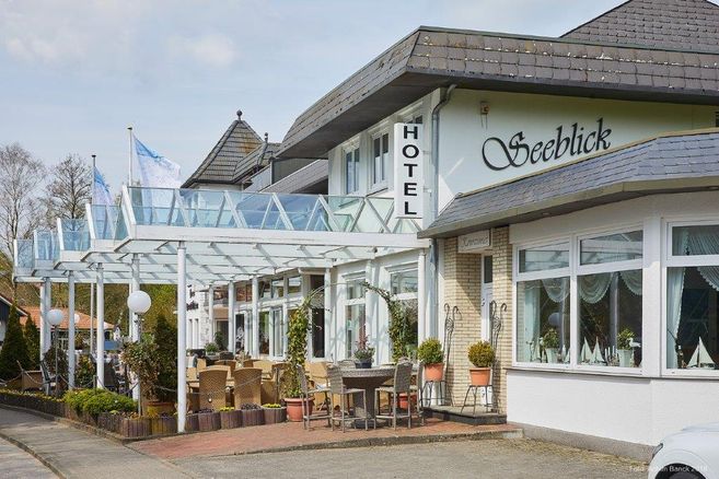 Außenansicht des Hotels Seeblick mit Terrasse und Sitzgelegenheiten.