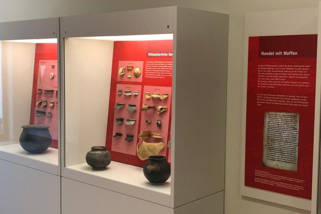 Ausstellungsstücke in Vitrinen mit rotem Hintergrund 