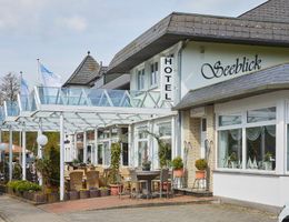 Außenansicht des Hotels Seeblick mit Terrasse und Sitzgelegenheiten.