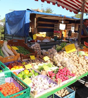 Ein bunter Markt mit frischem Obst und Gemüse. Verkäufer bieten eine Vielzahl von Produkten in Körben an.