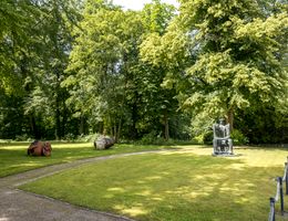 Skulpturen im Gerisch-Skulpturenpark Neumünster, umgeben von Bäumen und Rasenflächen.